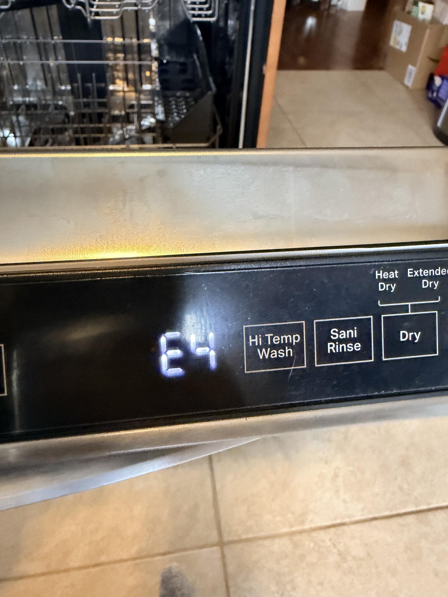 LG dishwasher pulled away from the cabinet showing the base pan where the leak sensor detects water and triggers the AE error code