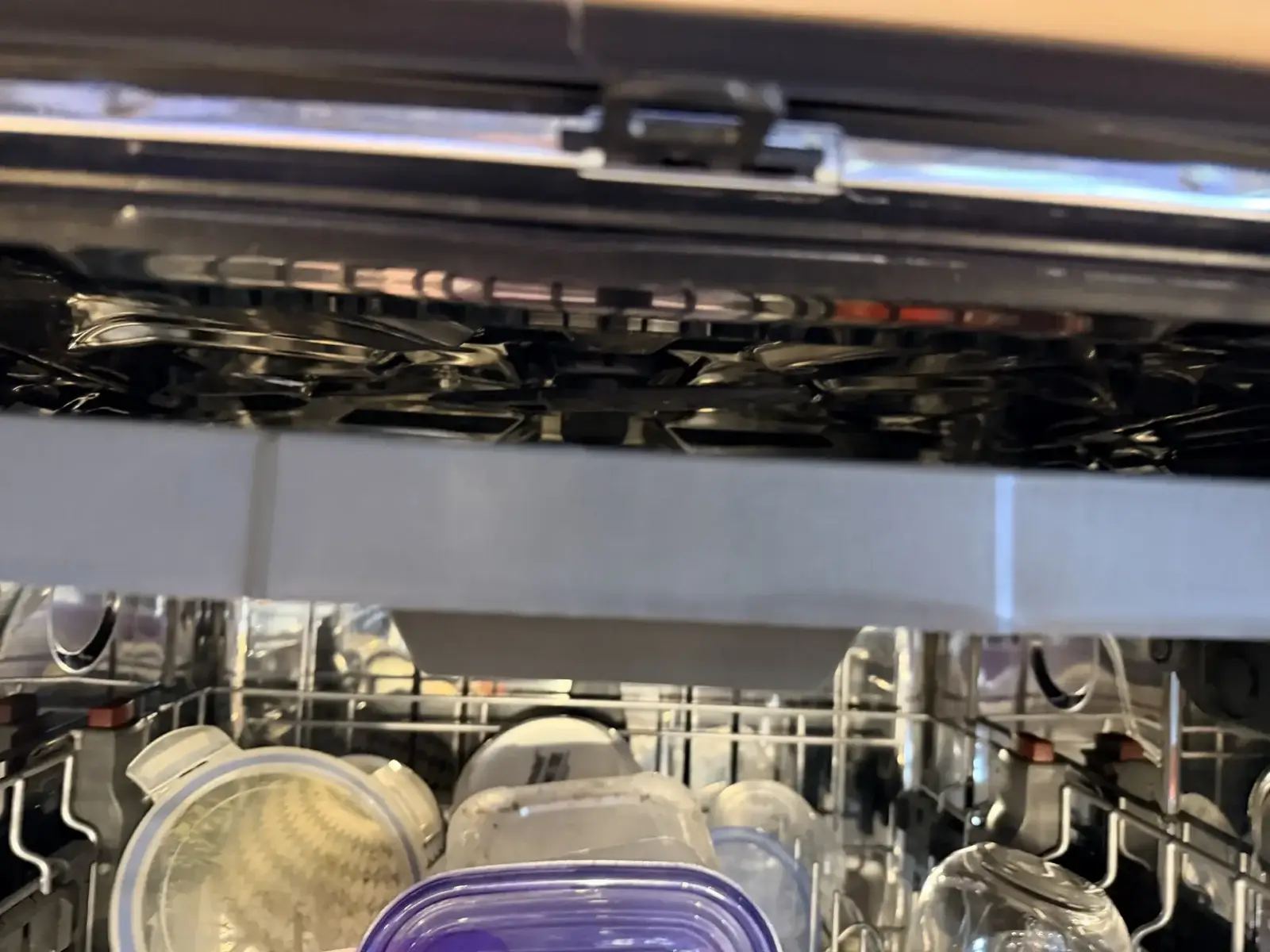 Frigidaire dishwasher interior at the end of a cycle with standing water in the tub — the visible symptom of a clogged filter or blocked drain hose