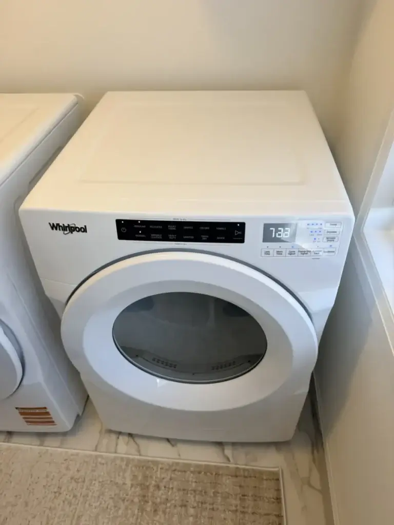 dryer repair white whirlpool front loading dryer digital controls stands beside